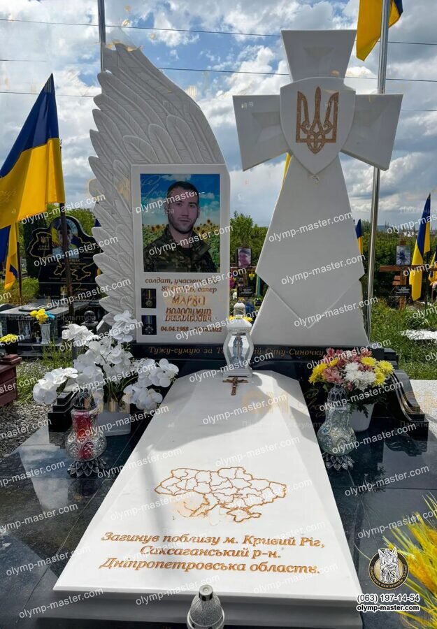 Белый памятник военному с казацким крестом, резным крылом и цветным фото на стекле.