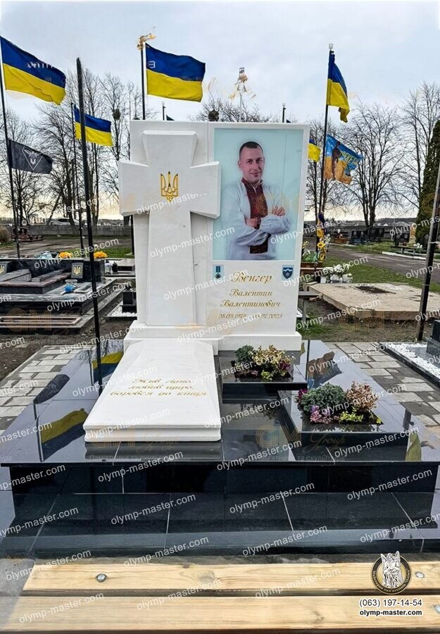 Белый памятник военному с объемным казацким крестом, золотым тризубом и большим вертикальным фотопортретом на стекле.